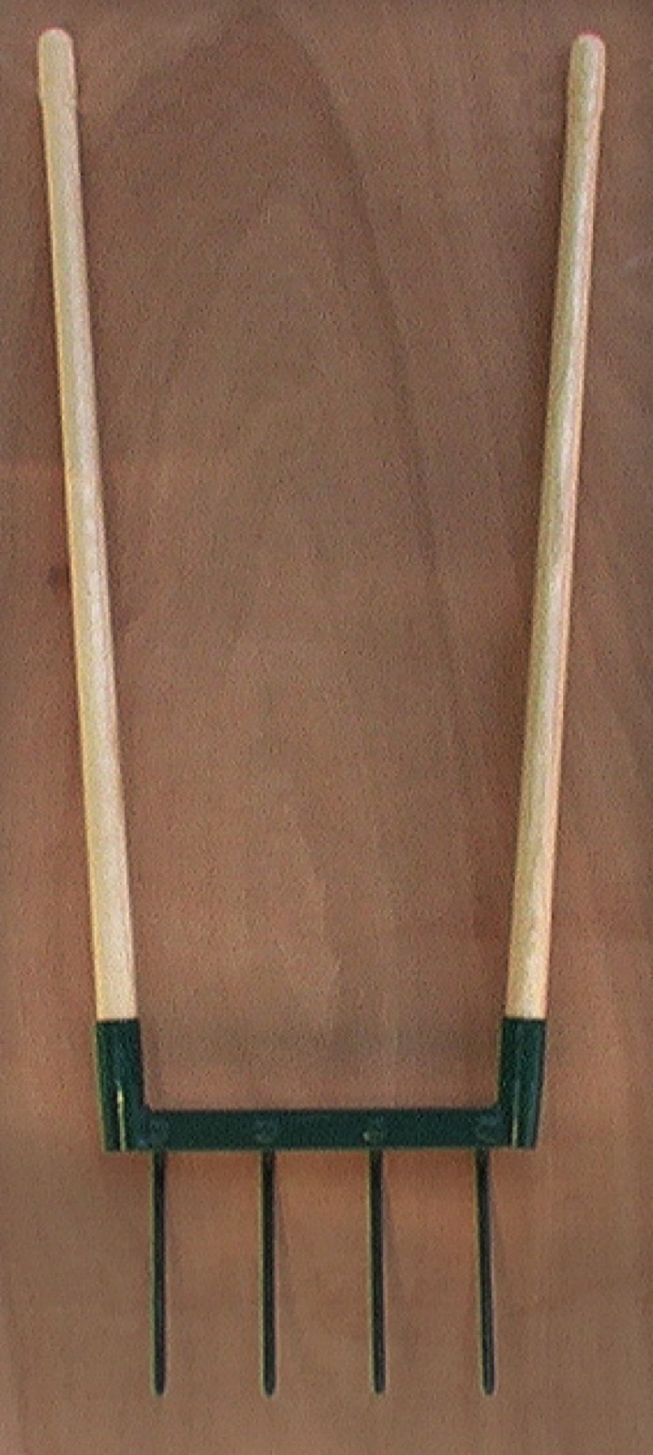 A broadfork with wooden handles and steel tines